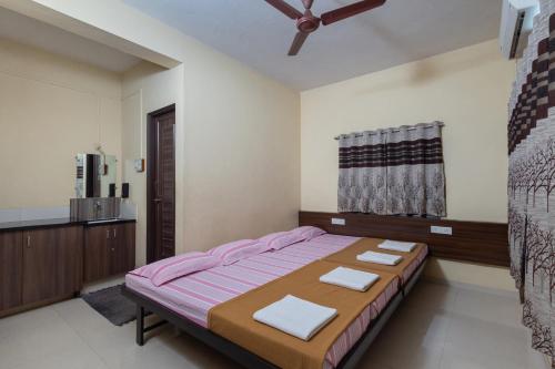 a bedroom with a bed with two towels on it at Hotel Ambika in Kolhapur