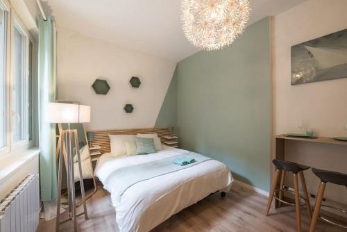 a bedroom with a bed and a chandelier at Studio Centre-ville Sur Cour in Toulouse