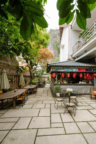 a patio with tables and chairs and a building at King Kong Homestay in Ninh Binh