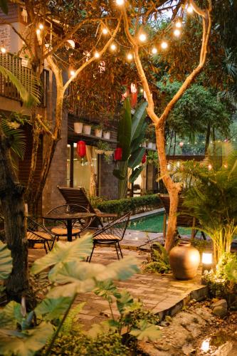 a backyard with a pool and a tree with lights at King Kong Homestay in Ninh Binh