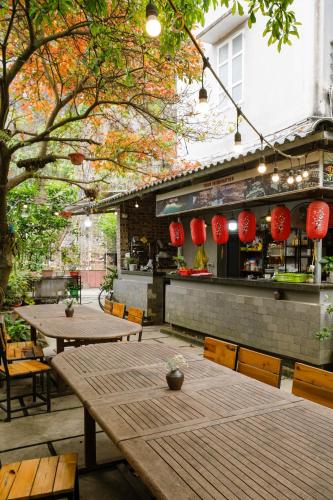 an outdoor patio with tables and chairs and red lanterns at King Kong Homestay in Ninh Binh
