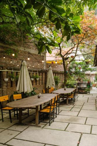 two tables and chairs with umbrellas on a patio at King Kong Homestay in Ninh Binh