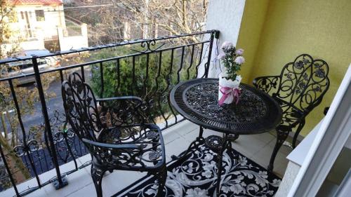 einen Tisch mit einer Blumenvase auf dem Balkon in der Unterkunft One Floor Apartment with Garden, Terrace & Grill in Bukarest