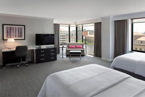 Habitación de hotel con cama, escritorio y TV. en JW Marriott Washington, DC, en Washington