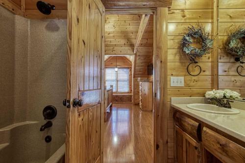 a bathroom in a log cabin with a sink at Prestigious, Luxury, Pool, Game Room, Mtn Views in Sevierville