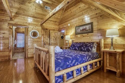 a bedroom with a bed in a log cabin at Prestigious, Luxury, Pool, Game Room, Mtn Views in Sevierville