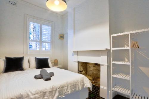 1 dormitorio con cama blanca y estante para libros en Good for Family 3 Bedroom House Darlinghurst with 2 E-Bikes Included, en Sídney