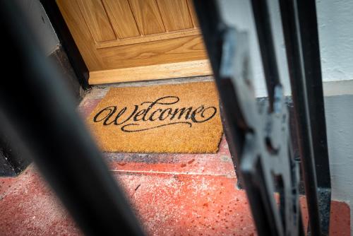 a door with the word welcome written on a door mat at Kings Arms Suites - Luxury Double - Waterfall Shower - Self Check In in Whitehaven