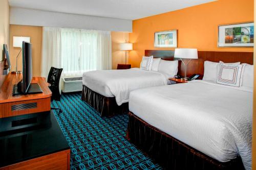 a hotel room with two beds and a flat screen tv at Fairfield Inn & Suites by Marriott Atlanta Alpharetta in Alpharetta