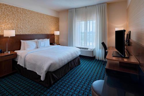 ダブリンにあるFairfield Inn & Suites by Marriott Dublinの大型ベッドとテレビが備わるホテルルームです。
