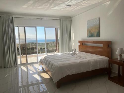 Villa Ferreira Punta Rucia near Ensenada beach في بونتا روسيا: غرفة نوم بسرير ونافذة كبيرة