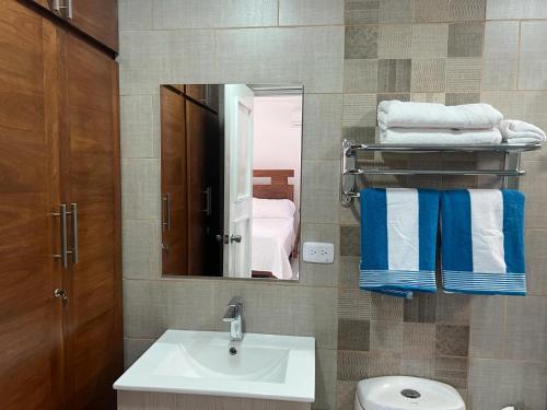 a bathroom with a sink and a mirror and towels at Villa Ferreira Punta Rucia near Ensenada beach in Punta Rucia
