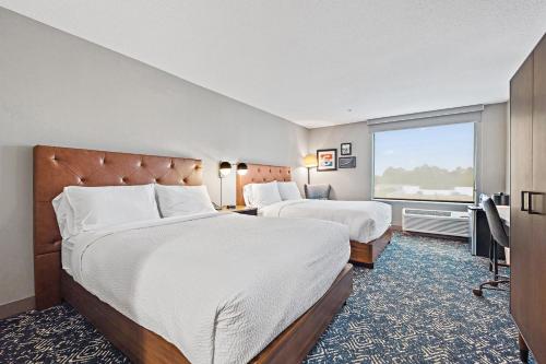 a hotel room with two beds and a large window at Four Points by Sheraton Jacksonville Baymeadows in Jacksonville