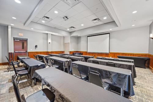 an empty room with tables and chairs and a whiteboard at Four Points by Sheraton Jacksonville Baymeadows in Jacksonville