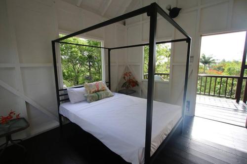 a bedroom with a canopy bed with a balcony at Sugar Mountain Cottage in Saint Mary