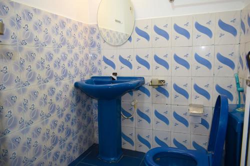 ein Badezimmer mit einem blauen Waschbecken und einem WC in der Unterkunft ROLEX GUEST HOUSE in Trincomalee
