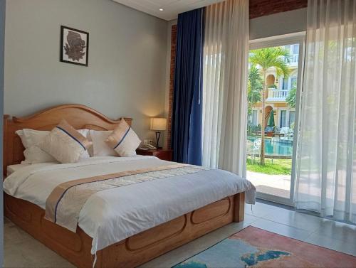 a bedroom with a bed and a large window at Sokchea Kampot Hotel in Kampot