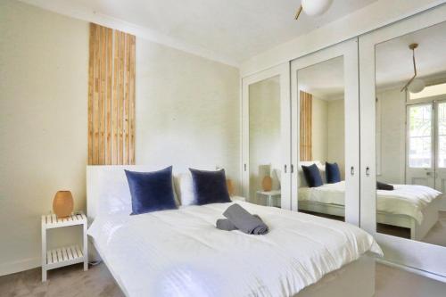 1 dormitorio con 1 cama blanca grande con almohadas azules en Ideal 3 Bedroom House in Chippendale with 2 E-Bikes Included en Sídney