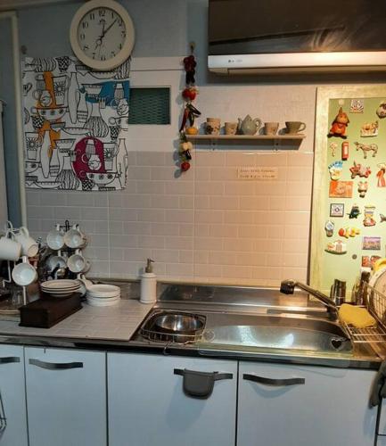 a kitchen with a sink and a clock on the wall at Sodamhang in Damyang in Damyang