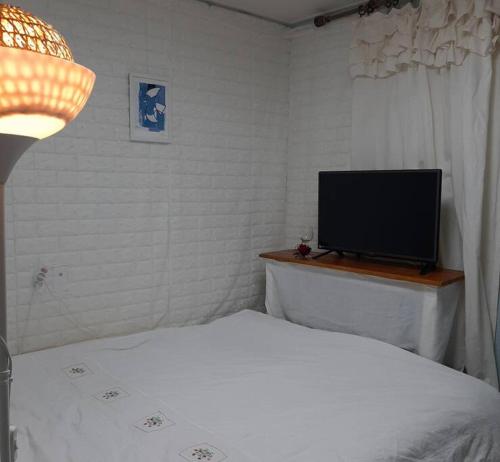 a bedroom with a bed and a flat screen tv at Sodamhang in Damyang in Damyang