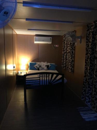 a dark room with a bed with a lamp and a table at Chan Beach Resort & Hotel in Bahūr