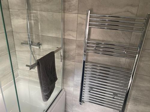 ducha con puerta de cristal y toalla en Newtons Lodge, en Nottingham