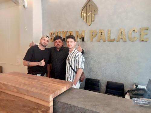 a group of three men standing next to a table at HOTEL SHYAM PALACE INDIA AGRA in Agra