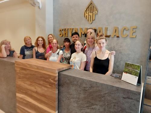a group of people posing for a picture behind a counter at HOTEL SHYAM PALACE INDIA AGRA in Agra