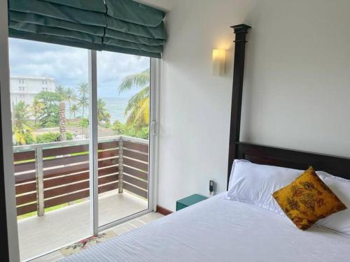 um quarto com uma cama e uma grande janela em Mount Avenue IX by Ceylon Spaces em Watumulla