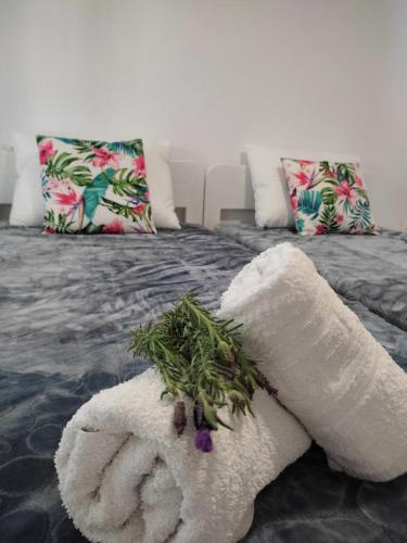 a white towel with flowers on a bed at Pefkari Bay House in Pefkari