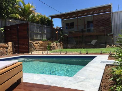 a swimming pool in a yard with a house at CC's @ Byron Self Contained Studio in Byron Bay