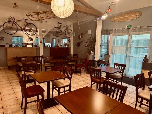 a restaurant with tables and chairs and bikes hanging from the ceiling at Ever Route 64 Brit Hotel Tarbes Ibos in Tarbes