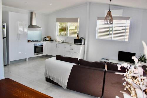 a living room with a couch and a kitchen at CC's @ Byron Self Contained Studio in Byron Bay