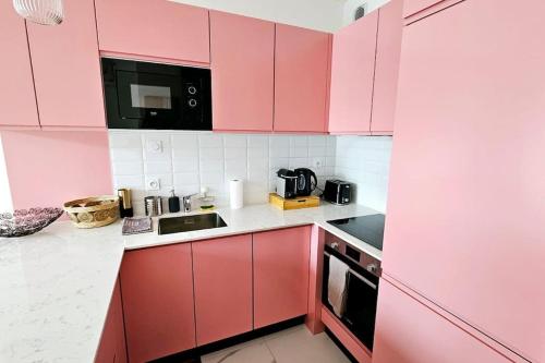 a kitchen with pink cabinets and a sink at Lilas Rose in Thonon-les-Bains