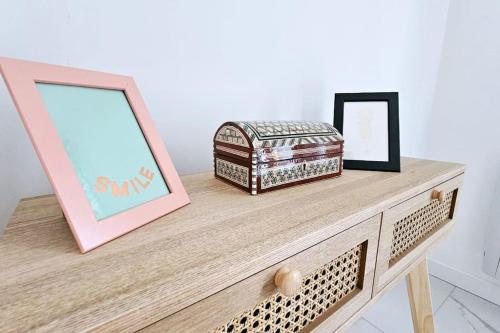 a dresser with two pictures and a mirror on it at Lilas Rose in Thonon-les-Bains