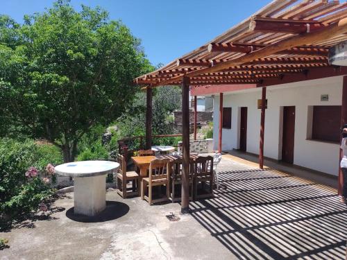 un pabellón con una mesa y sillas en un patio en Hostería La Porteña - La Serranita en 