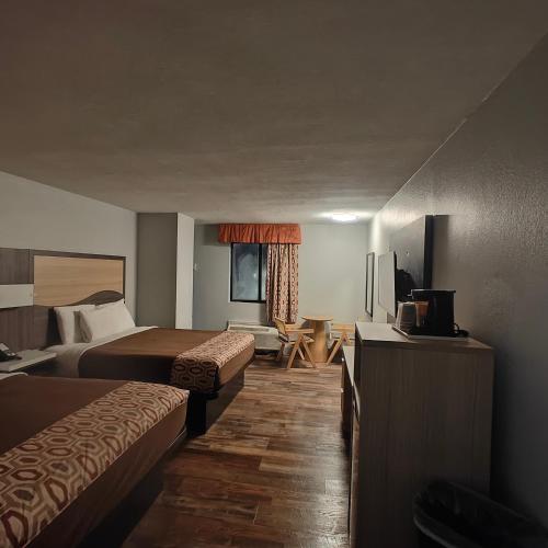 a hotel room with two beds and a television at Mountain Vista Inn & Suites - Walking Distance to the Island in Pigeon Forge