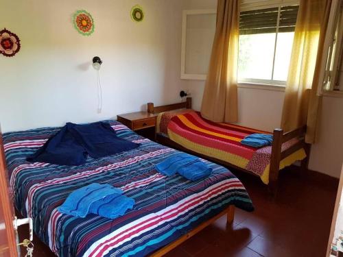 een slaapkamer met 2 bedden en een raam bij Hostería La Porteña - La Serranita in La Bolsa