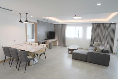 The Glory Hotel and Residence في Mabalacat: غرفة معيشة مع طاولة وكراسي وأريكة