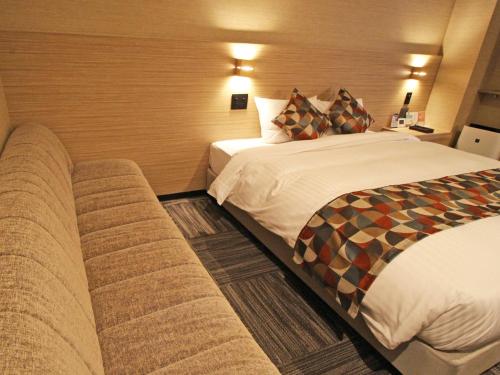 a hotel room with a bed and a couch at Astil Hotel Shinosaka Precious in Osaka