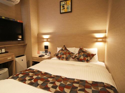a hotel room with a bed and a flat screen tv at Astil Hotel Shinosaka Precious in Osaka