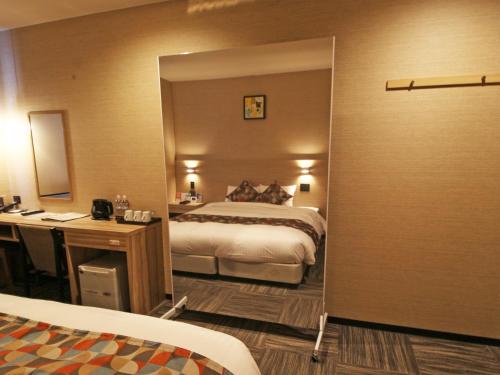 a hotel room with a bed and a mirror at Astil Hotel Shinosaka Precious in Osaka