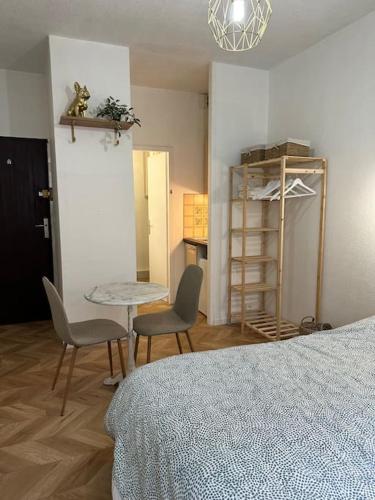 une chambre avec un lit, une table et des chaises dans l'établissement Studio Cure Thermale Dax - proche parking, à Dax