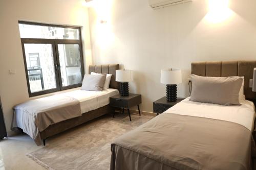 - une chambre avec 2 lits et une fenêtre dans l'établissement WAAFI CITY CENTER RESIDENCE, à Djibouti
