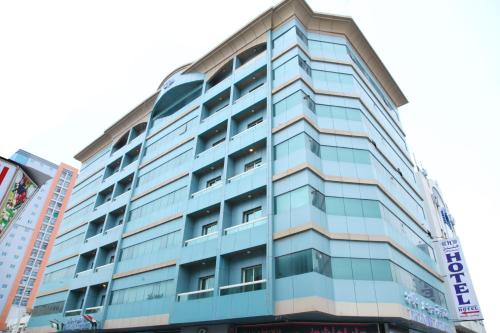 Un alto edificio blu con un cartello sopra di Zenith Smart Vacation Homes, Ajman ad Ajman