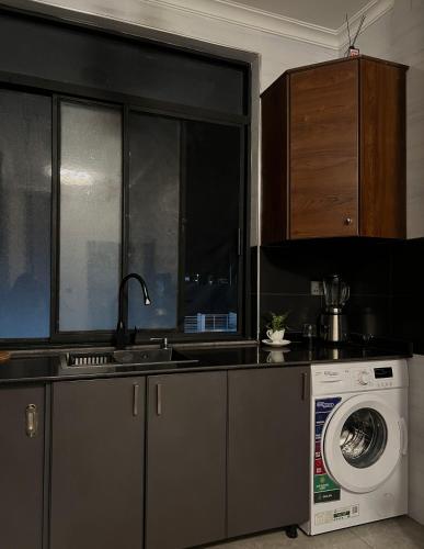 a kitchen with a sink and a washing machine at CosyNook in Kigali