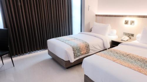 Postel nebo postele na pokoji v ubytování Eno Front One Hotel Semarang