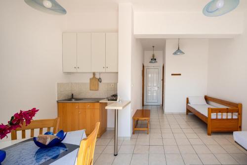 a kitchen and a living room with a table and chairs at Alexis Apartments in Stavros