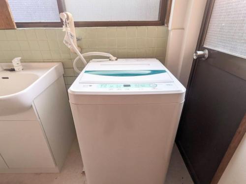 a washing machine in a bathroom with a sink at 北アルプスの麓｜一軒家のシェアハウス内の和室宿／一匹のひつじ邸 in Ō-shinden