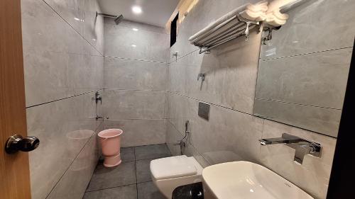 y baño con aseo blanco y lavamanos. en Hotel Lotus Blue By De Tulip en Bhopal